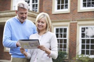 Mature Couple Standing Outside House